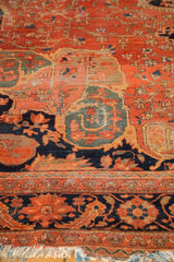 Intricate dark blush and navy floral vinery on an antique Farahan carpet, with worn fringe.
