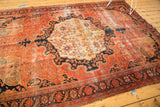 Antique Farahan Sarouk rug corner with intricate floral vinery and worn dark blush pile.