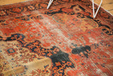 Antique Farahan Sarouk carpet detail showing significant threadbare wear across dark blush and navy.