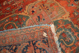 Folded antique Farahan Sarouk rug showing threadbare blush and green pile, tattered fringe.