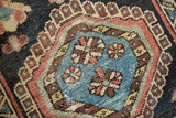 Vintage Karaja rug detail showing sky blue field and diamond hook-latch border.
