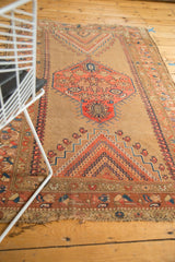 Rectilinear blush and navy geometric patterns on a circa 1910s Antique Caucasian rug's tattered end.