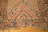 Antique Caucasian rug end with hard tatter, showing blush, camel, and blue geometric patterns.
