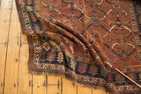 Fringed corner of vintage Kamseh rug, with asymmetric Herati-inspired geometric pattern.