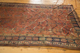 Vintage Kamseh carpet corner with madder red Herati-inspired motifs and navy borders.