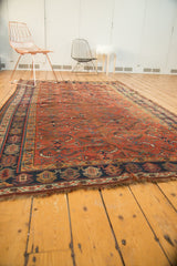 Vintage Kamseh carpet's navy border with intricate geometric patterns and fringed end.
