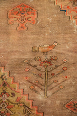 Antique Doroksh rug detail: blush tree of life with perched bird, stepped outlines on beige.