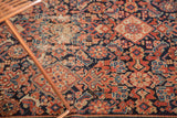 Intricate Herati and diamond motifs with time-softened madder red, navy, ivory on an antique Malayer rug.