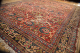 Vintage Mahal carpet corner, cherry red floral field, delicate palmettes, navy border, visible wear.
