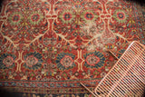 Worn cherry red field, floral vinery, and navy blue border of vintage Mahal carpet.