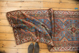 Sapphire blue and madder red medallions with serrated leaf border on a folded Qashqai runner.