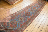 Vintage Qashqai rug detail: sapphire blue, brick red geometric medallions and patterned border.