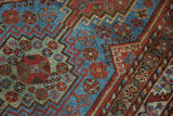 Gem-tone geometric patterns and serrated leaf border on a Vintage Qashqai rug.
