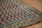 Antique Caucasian runner corner with repeating boteh motifs and abrash pale blue border.