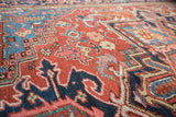 Antique Heriz rug detail showcasing vivid jewel-toned corner spandrels and speckled floral patterns.