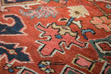 Antique Heriz carpet pile texture: brick red field, navy, blush curled floral blossoms, even wear.