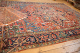 Antique Heriz carpet corner, revealing vivid jewel-tone spandrels and 'salt and pepper' florals.