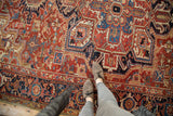 Vintage Heriz carpet with intricate geometric vinery and floral patterns in cherry red, navy, and beige.
