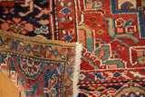 Folded vintage Heriz rug corner, revealing hand-knotted foundation, intact selvage, and red, blue patterns.
