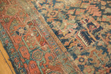 Antique Heriz rug detail: patched field, worn texture, faded indigo and rust geometric vinery.