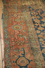 Close-up antique Persian Heriz border, terra cotta, indigo geometric vinery, and aged patina.