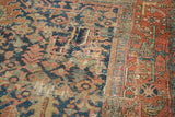Detail of antique Heriz carpet showing indigo and rust geometric motifs and visible patchwork.