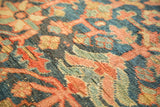 Close-up of antique Heriz rug pile: stylized vinery and blossoms in indigo, terra cotta, and sea foam green.