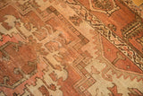 Vintage Heriz carpet's geometric vinery in tone-on-tone faded chestnut, terra cotta, and ivory.