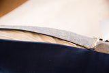 Open zipper on pillow, revealing cream insert and blue dotted and solid fabrics.