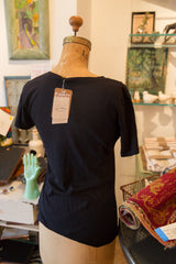 Back of the women's black V-neck tee with its Rug Addict brand tag attached.