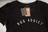 Close-up of the Farm Fresh tag and Rug Addict hangtag on the black V-neck shirt.