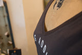 Angled view of the fine v-neckline and block text on a heathered gunpowder t-shirt.