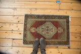 Vintage Oushak rug corner, celadon stepped medallion, brick red abrashed field, geometric border.