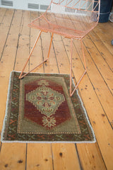 Vintage Oushak rug with stepped celadon medallion, palmette finials, and abrashed burgundy field.