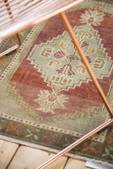 Vintage Oushak rug's bottom border, celadon, tangerine, and bronze geometric motifs with fringe.