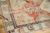 Distressed vintage Oushak rug showing worn pile with exposed foundation, brick red, and ivory hues.