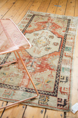 Worn geometric patterns and brick red tones on a vintage Oushak rug corner.