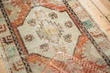 Distressed Oushak rug with worn pile, geometric motifs in brick red, ivory, and mint green.