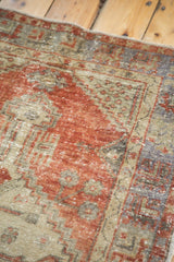 Distressed Oushak rug texture with faded terracotta, ivory, and muted blue geometric design.