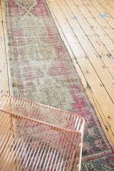 Distressed vintage Oushak runner with faded aubergine, antique ivory, and soft charcoal tones.
