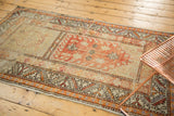 Distressed Oushak runner with tangerine, brick red, and ivory floral and serrated leaf patterns.