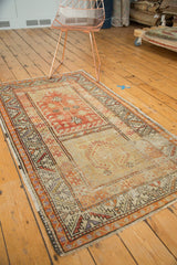 Distressed Oushak runner featuring antique ivory, tangerine, and geometric border patterns.