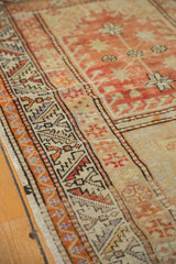 Textured terra cotta field and distinct geometric border of a distressed Oushak runner.