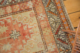 Distressed Oushak runner with rich brick red, beige, tangerine geometric patterns and serrated border.
