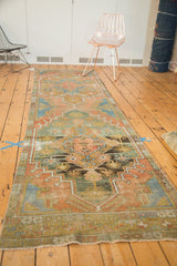Distressed vintage Oushak runner showing geometric stylized floral patterns in terra cotta and teal.