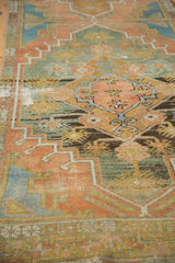 Geometric stylized floral patterns on a distressed Oushak runner with terra cotta, teal, and exposed knot heads.