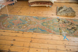 Distressed pile texture showing geometric floral motifs in terra cotta, teal, and ivory.