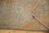 Distressed Oushak rug fragment, showing softened pile, faded floral motifs, and secured edge.
