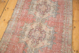 Repeating medallions and even wear on a distressed vintage Oushak runner.