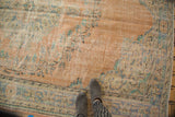 Distressed vintage Oushak rug, worn dusty peach pile with exposed foundation and floral motifs.